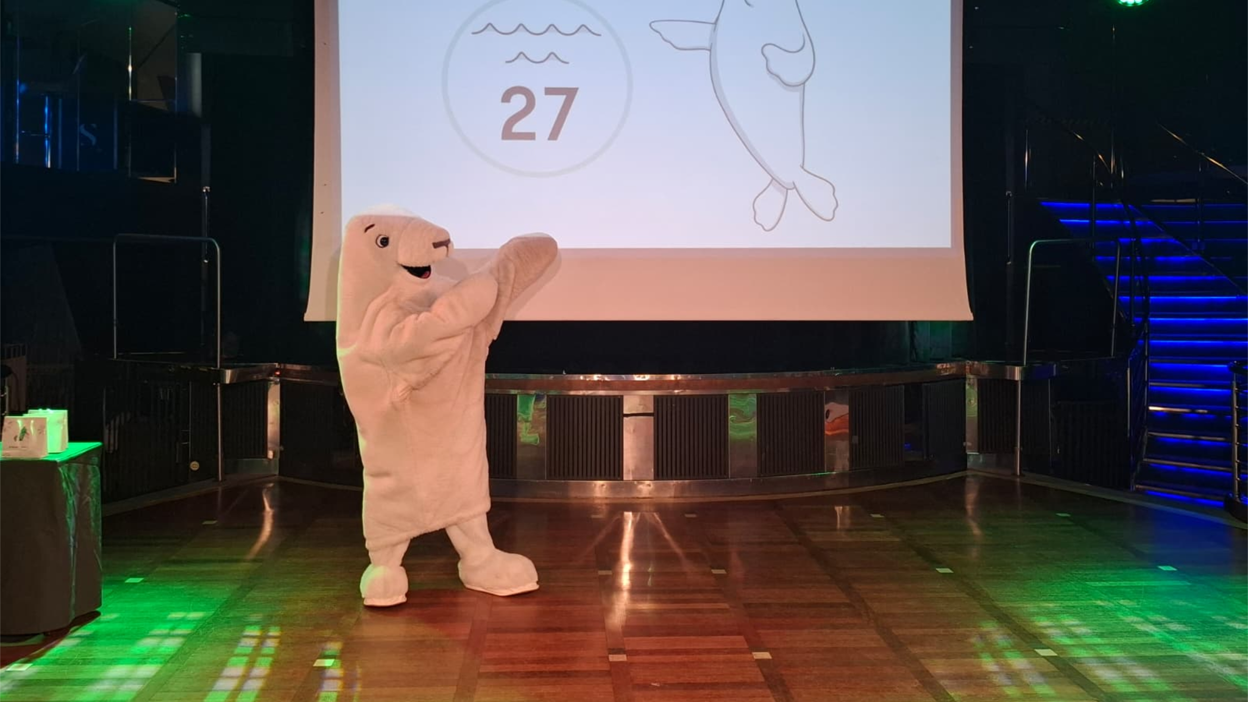 Värd som ropar ut nummer under ett livligt bingo i Starlight Show Bar ombord på ett Tallink Silja Line-kryssningsfartyg.