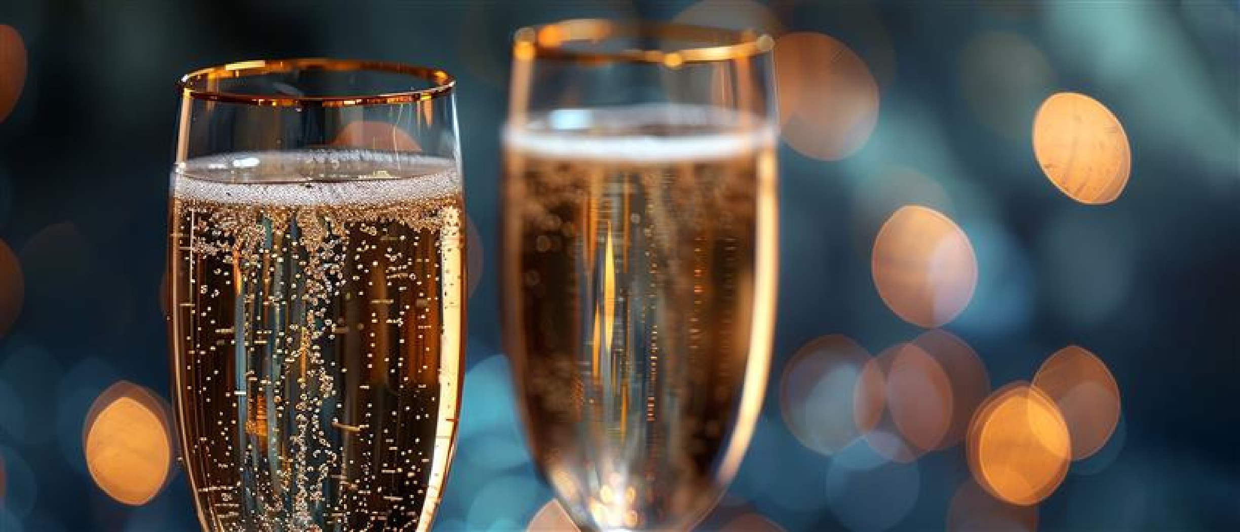 Kaksi samppanjalasia sinisellä taustalla heijatuksineen