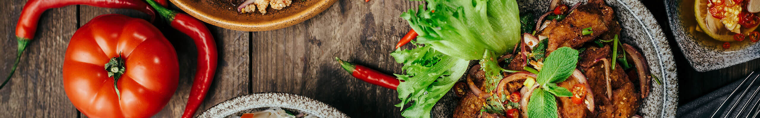 Valik värviliste koostisosadega roogasid, mida kaunistavad tšillid, tomat, küüslauk ja erinevad kastmed.