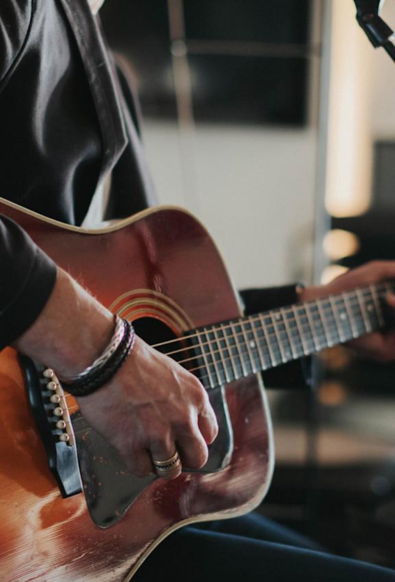 En man med gitarr och mikrofon.
