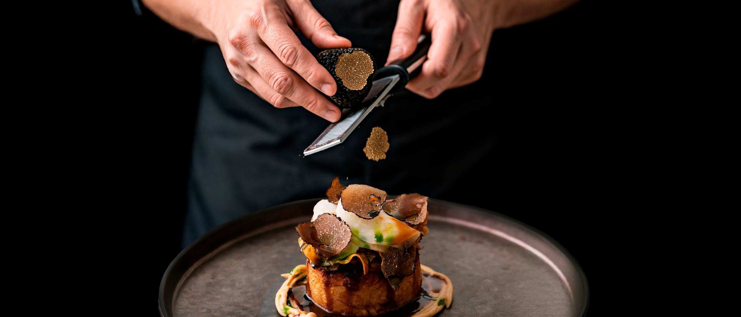 Man grating truffle over food