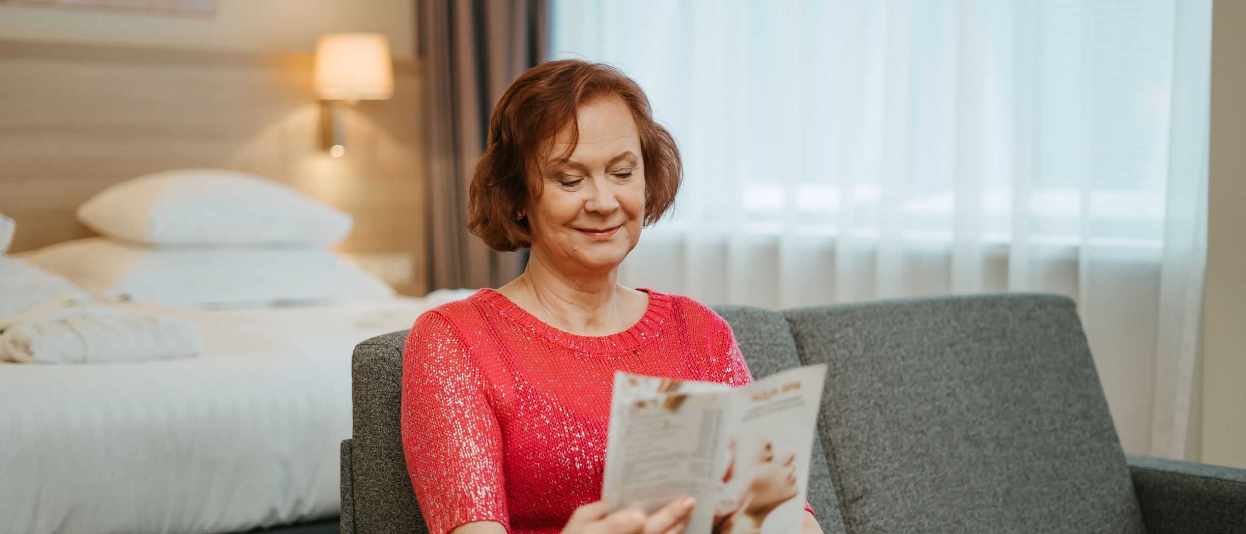 Elderly woman reading in a hotel room