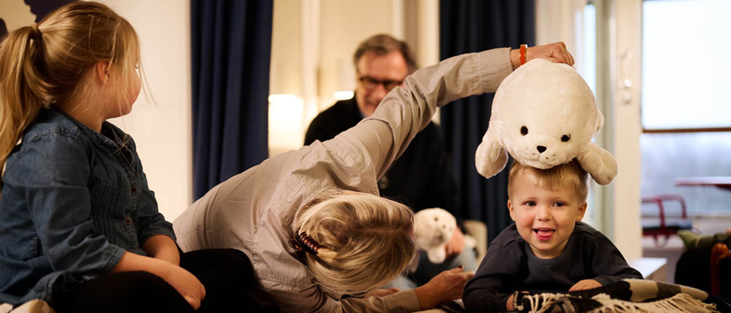 Två vuxna umgås med sina barnbarn i en Marimekko-dekorerad hytt ombord Silja Symphony