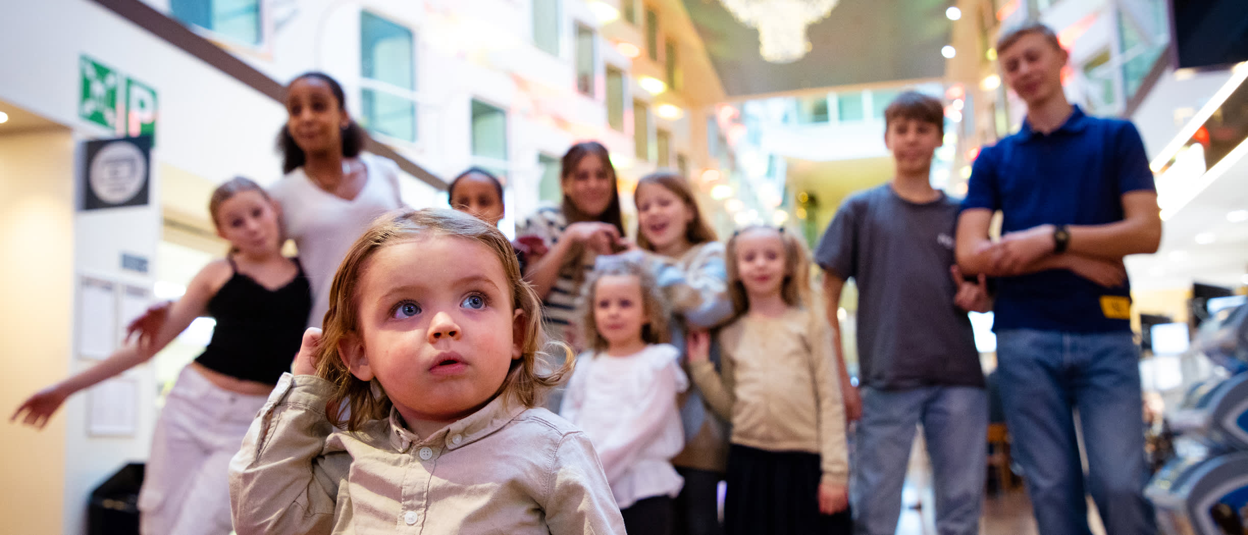 Joukko eri ikäisiä lapsia Silja Serenade -laivan promenadella