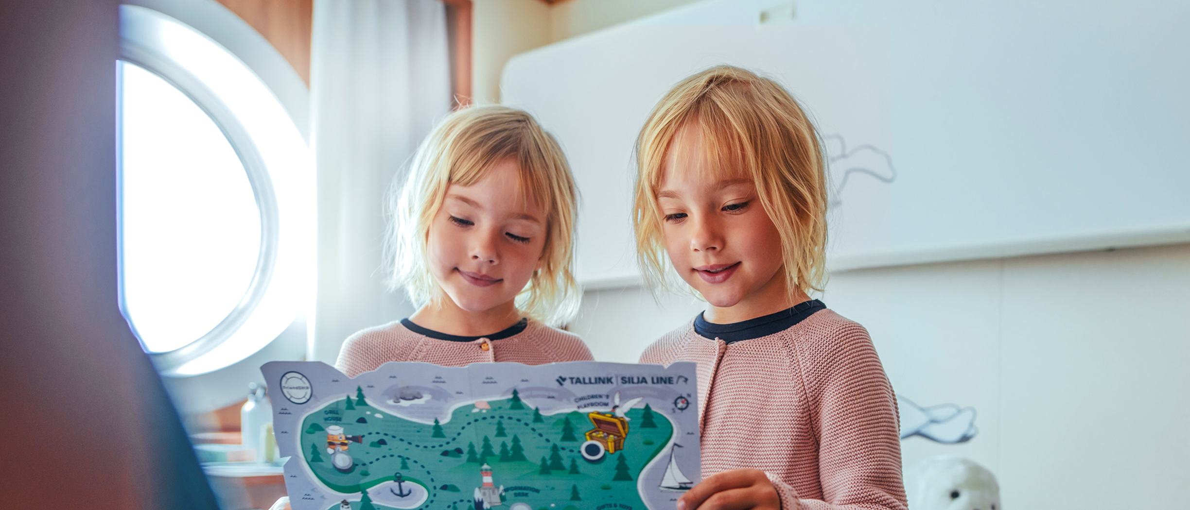 Kaksostytöt tutkivat FriendSHIP-aarrekarttaa laivan hytissän