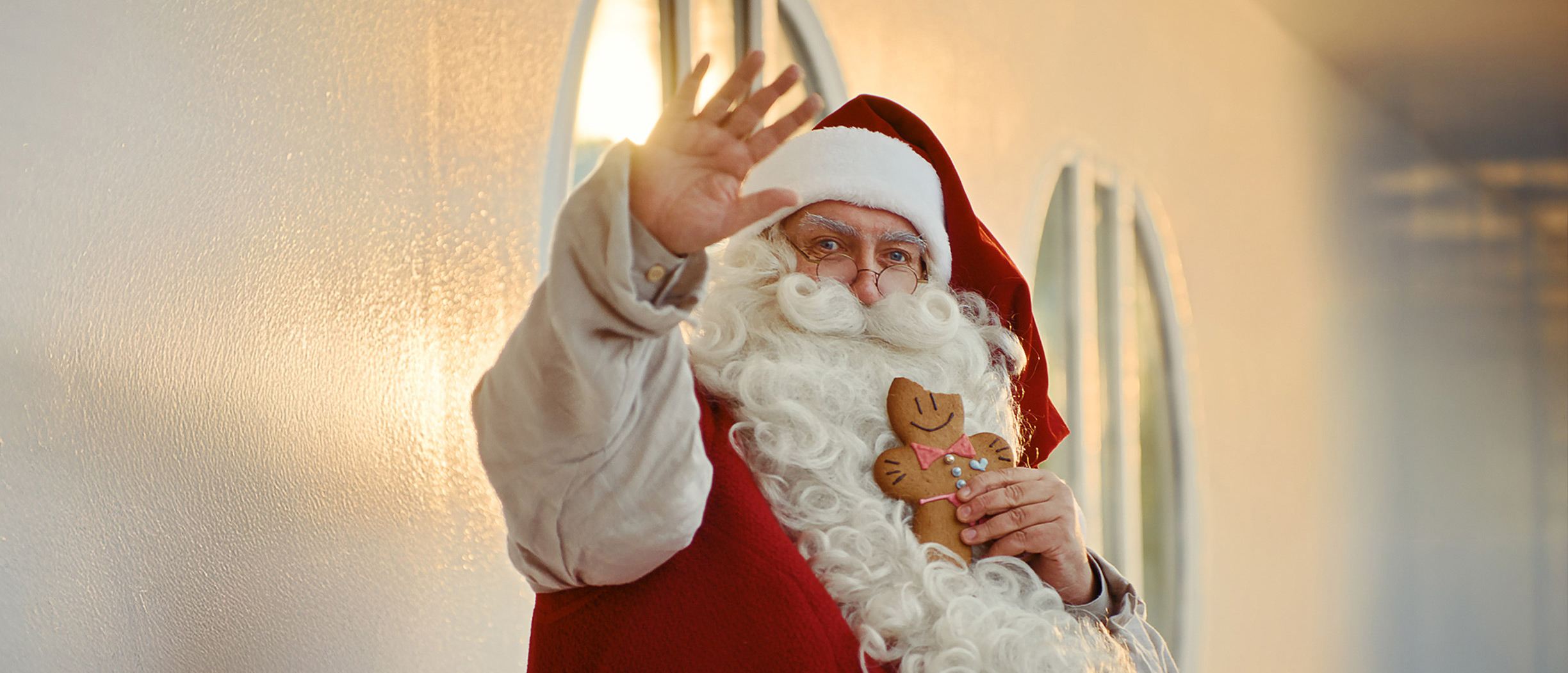 Tomten vinkar till kameran när han sitter utomhus på ett kryssningsfartyg