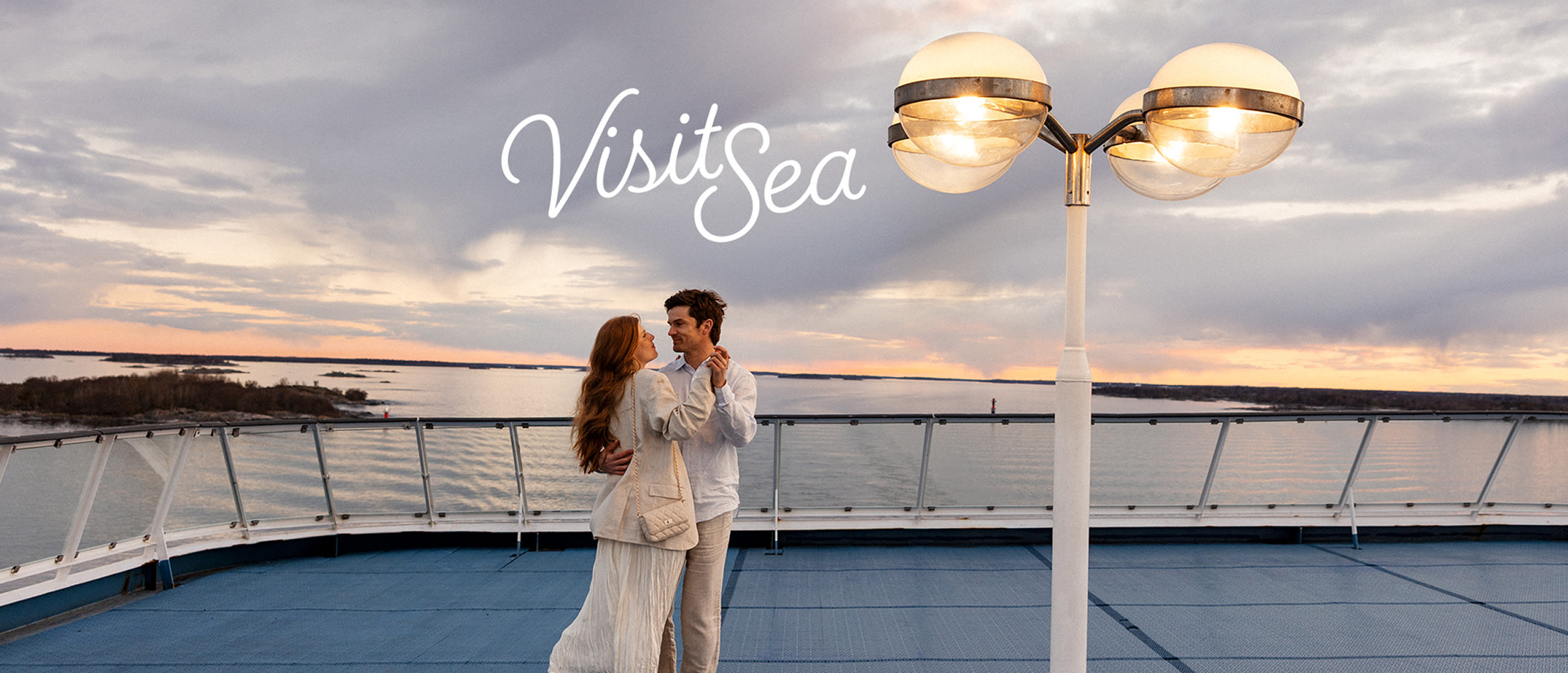 Couple on the open deck of a Tallink Silja ferry, enjoying Baltic Sea views and dancing together at sunset