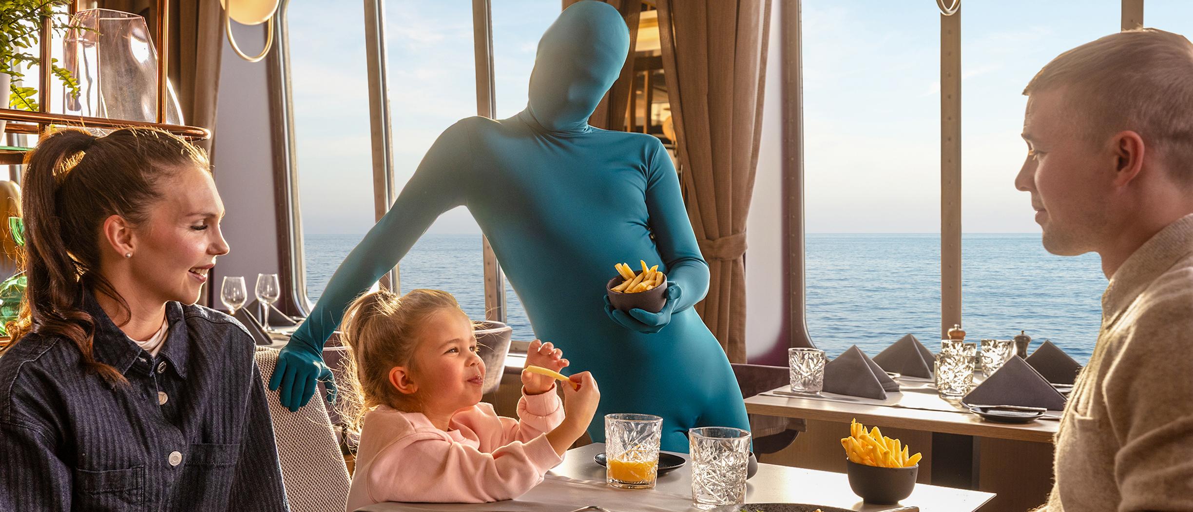 Sinises kostüümis mees koos perekonnaga laevarestoranis