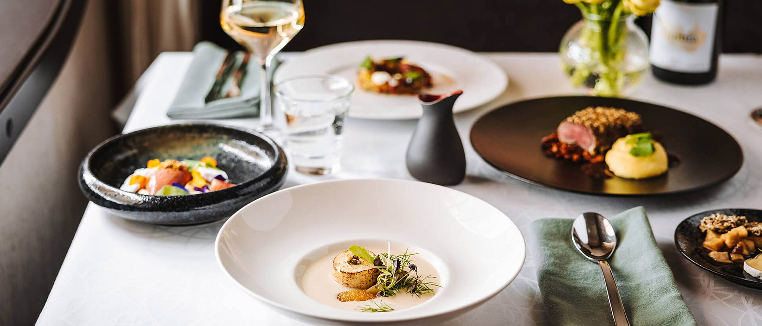 The Chef’s Kitchen fine dining dishes on Baltic Queen, including plated starters, main course, dessert, and wine