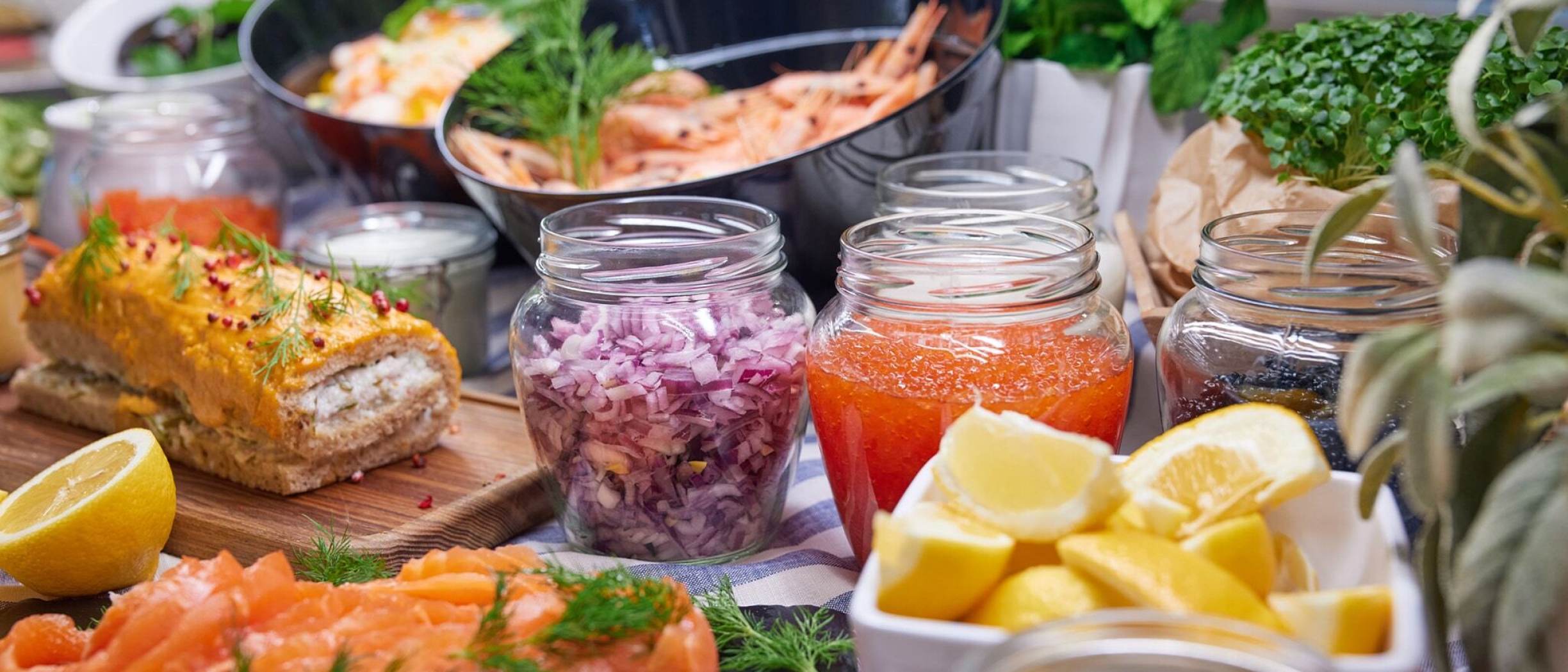 A vibrant Nordic buffet display on board Silja Symphony, featuring smoked salmon, prawns, roe, herbs and lemon wedges served with fresh accompaniments.
