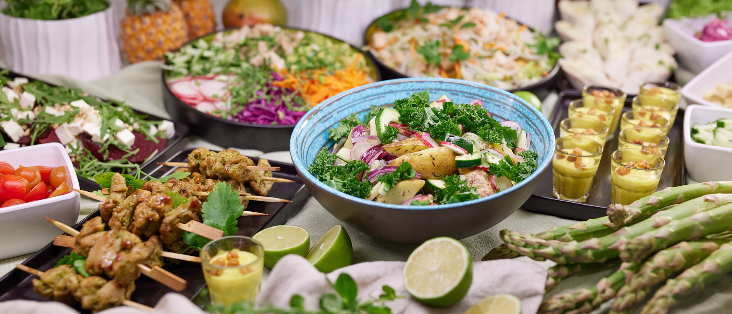 A colourful selection of fresh Nordic buffet dishes on board a Tallink ship, featuring salads, grilled skewers, asparagus, herbs and citrus