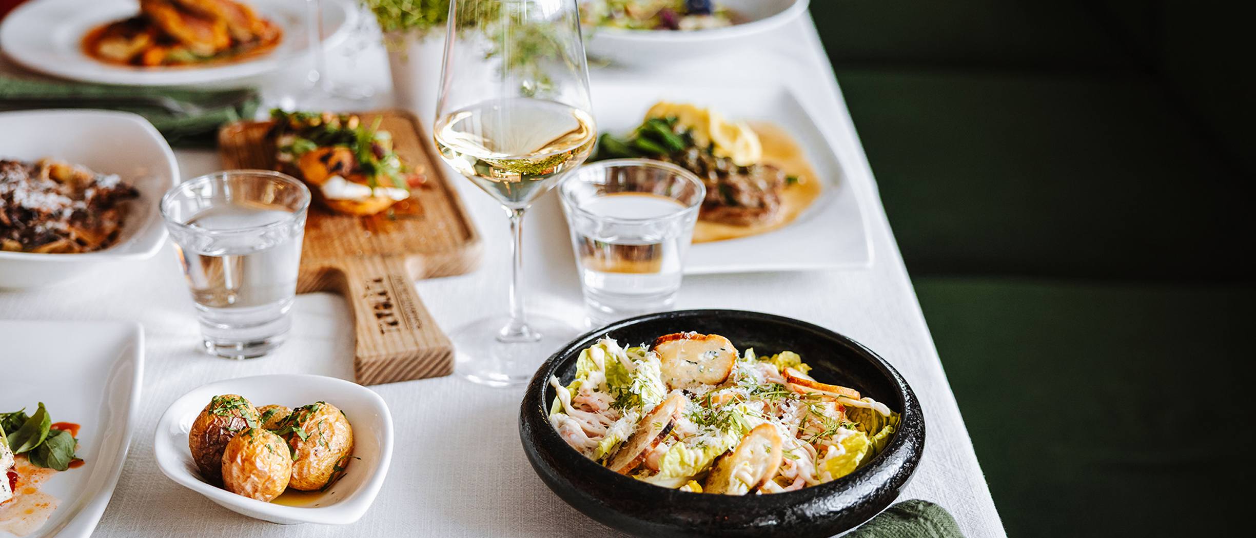 A beautifully set table at Tavolata Italian restaurant on a Tallink ship, featuring Mediterranean dishes, salads, and desserts served in a relaxed atmosphere.