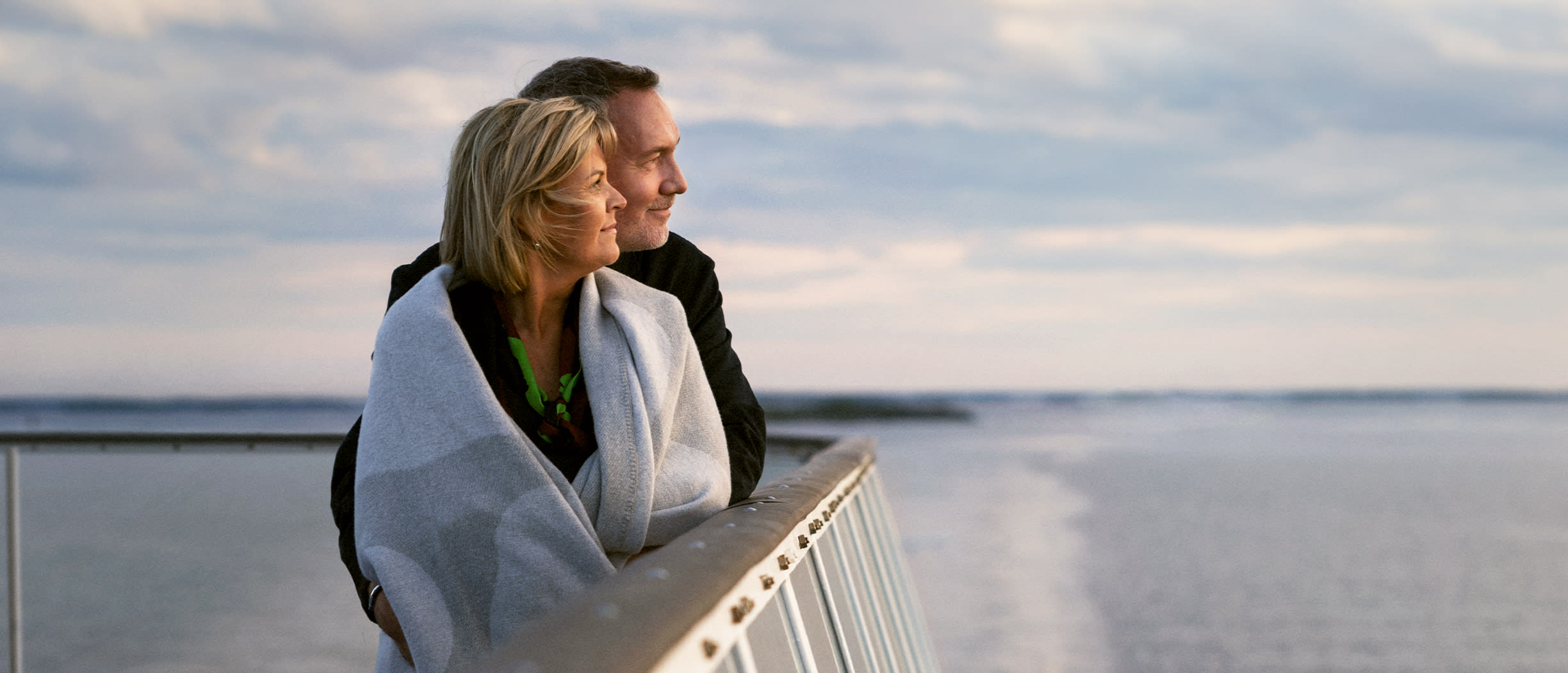 Ett par står på utedäck på ett av Tallink Silja Lines kryssningsfartyg.