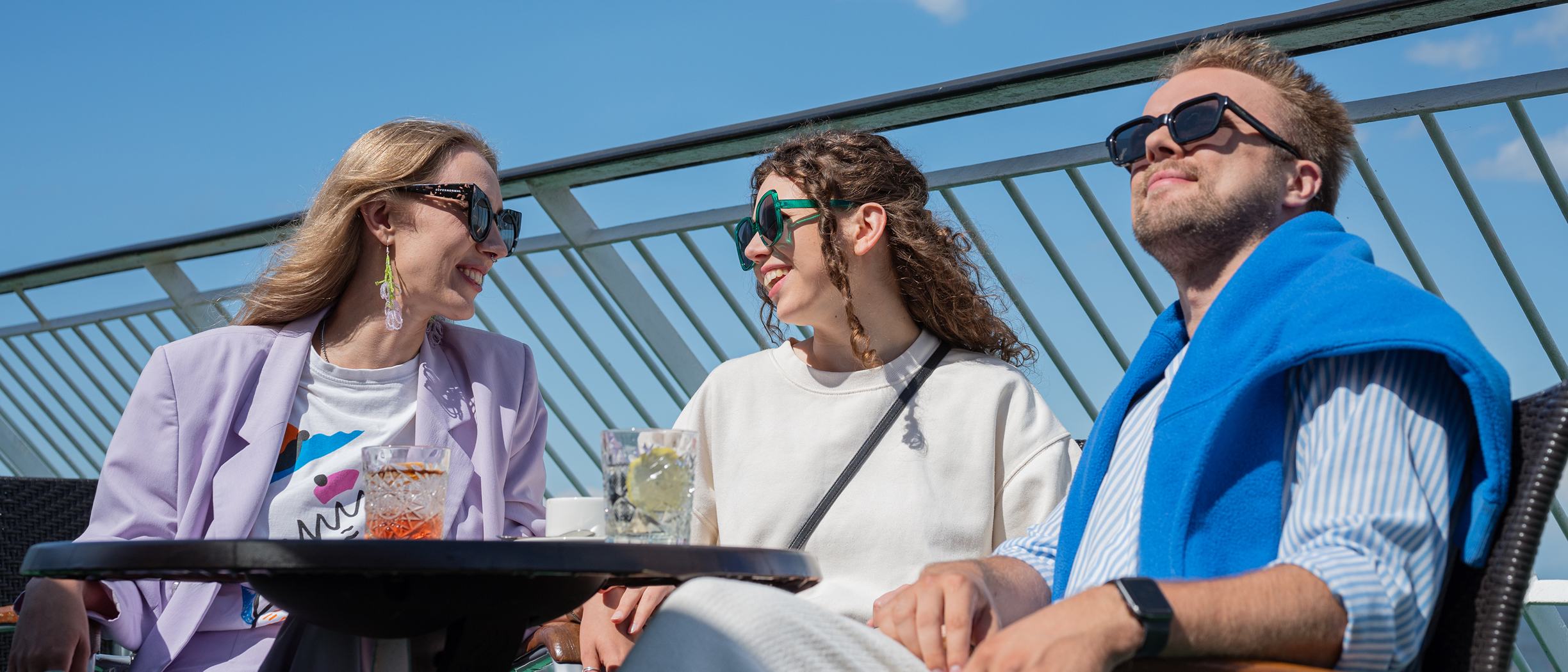 Tre vänner sitter på soldäck på en kryssning