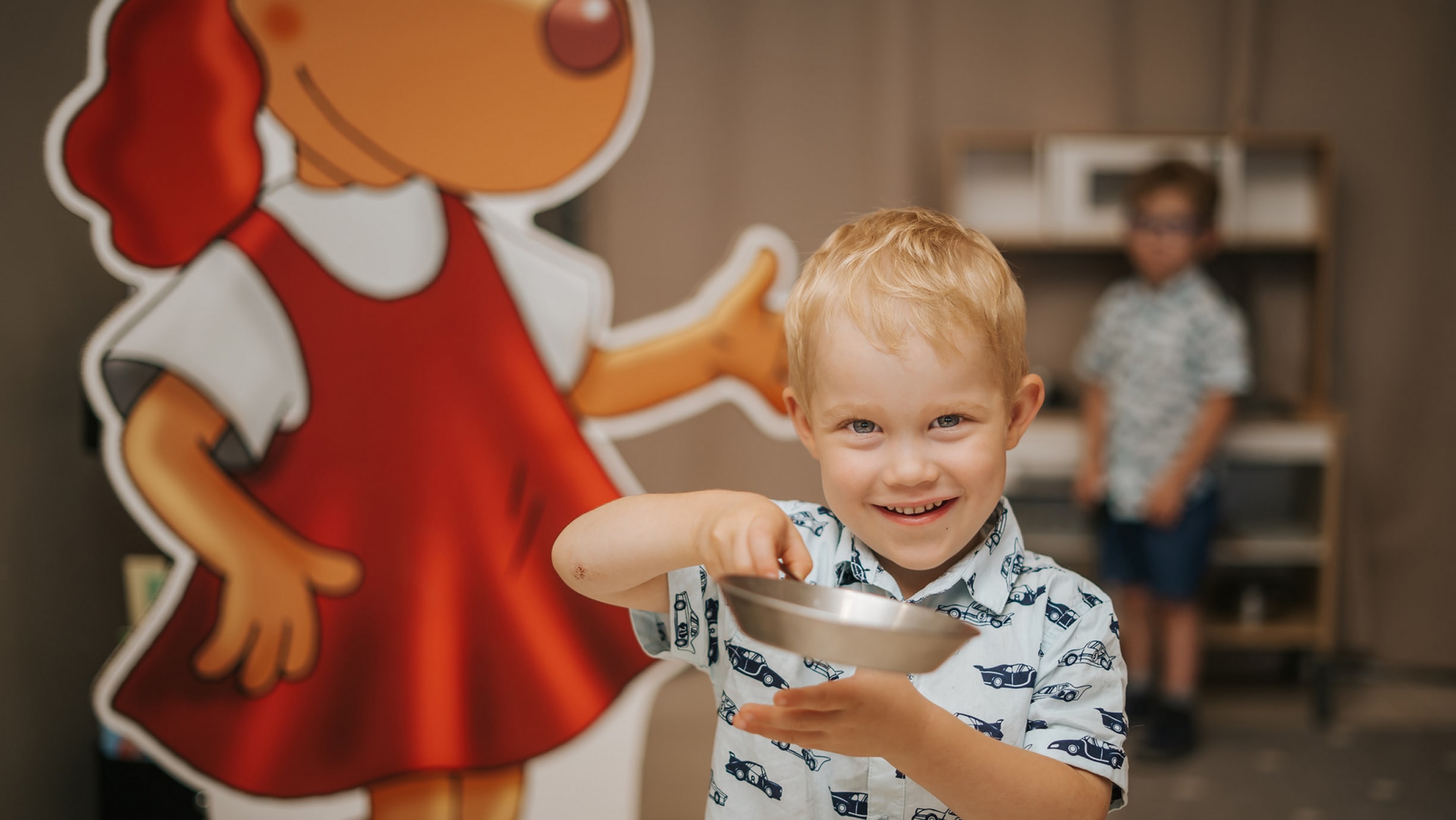 A boy playing with dishes in a restaurant's children's corner