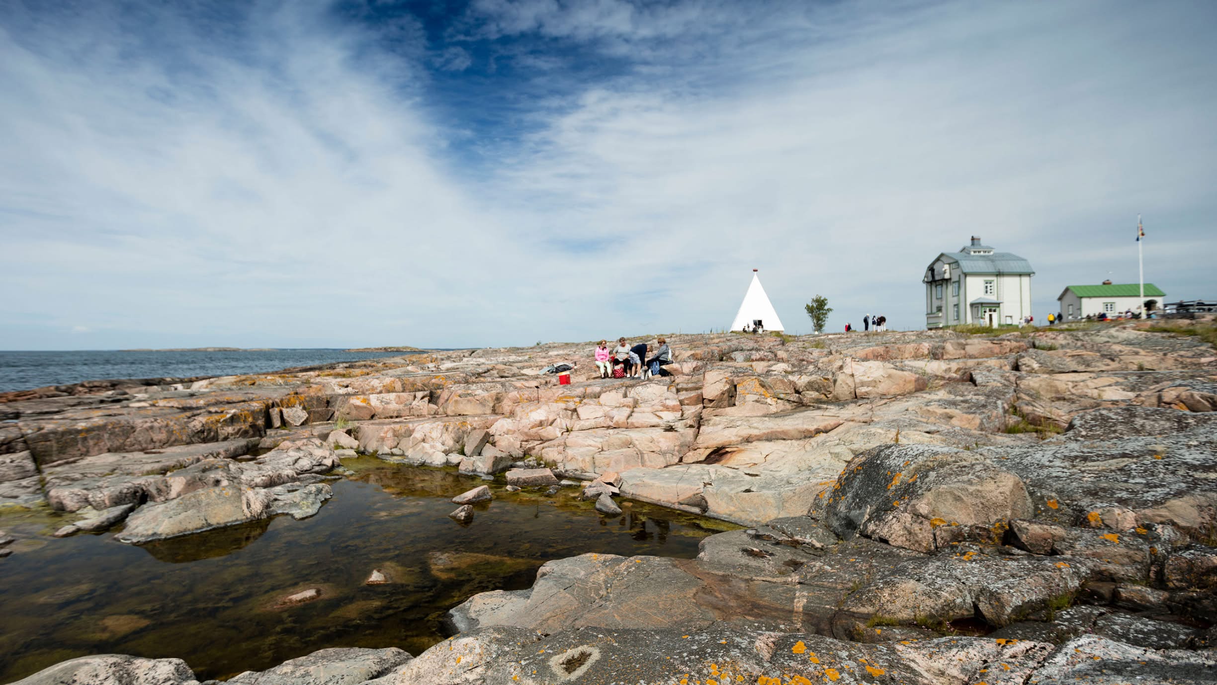 Familj sitter på klippor på Åland
