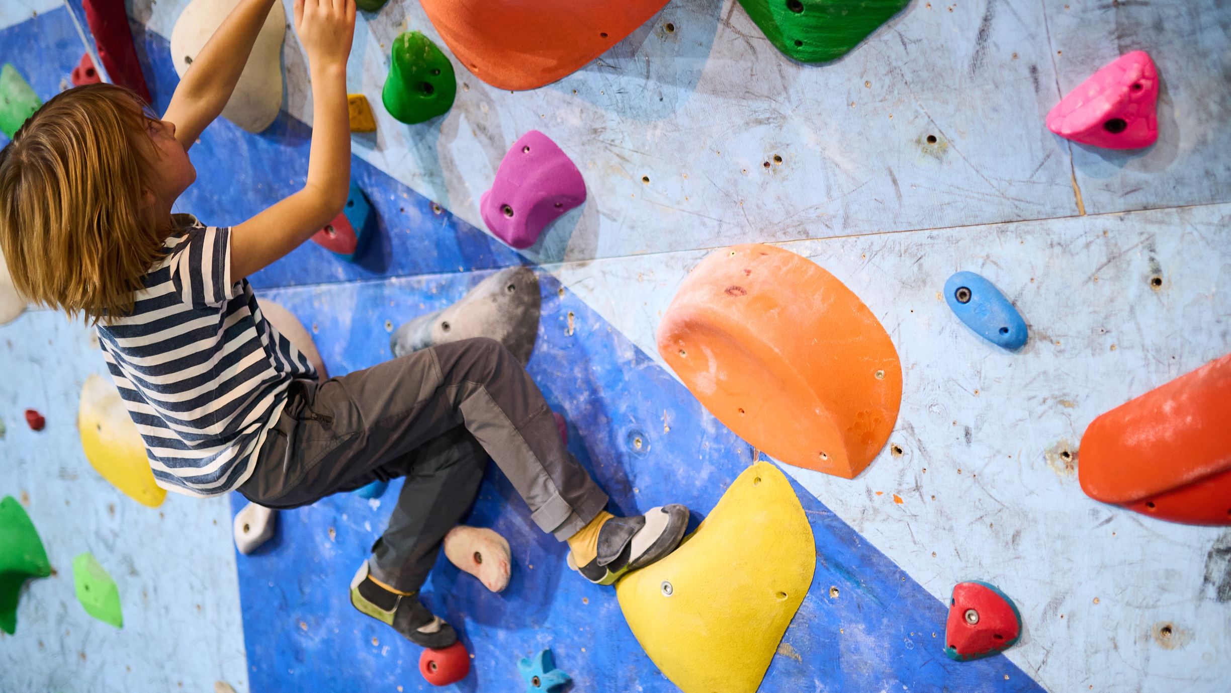 Koolireis Superpark Vantaa külastusega spordipäeval, poiss ronimas ronimisseinal 