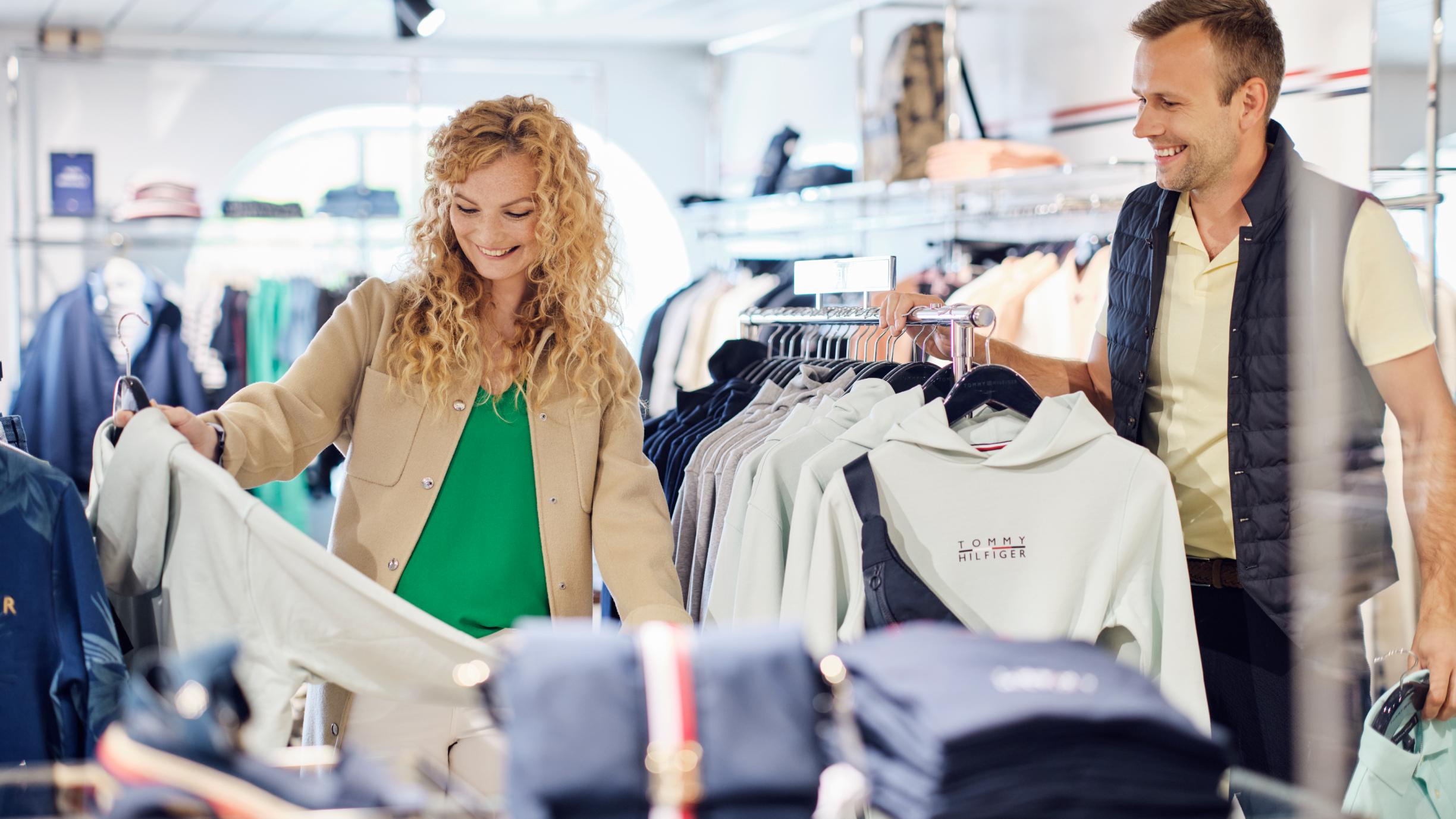Kvinna och man kollar på kläder i butik