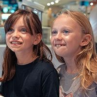 Två flickor står och tittar på en chokladfontän på en bufférestaurang ombord Tallink Silja Lines fartyg